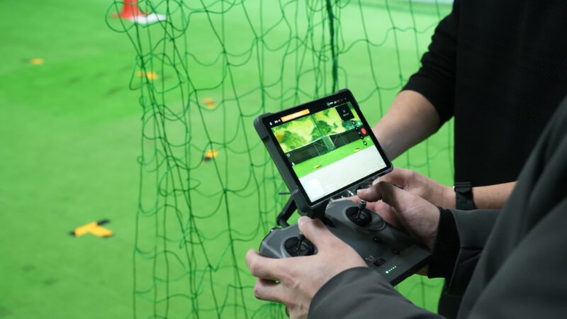 AZAXドローンスクールで操作方法を教えてもらう様子